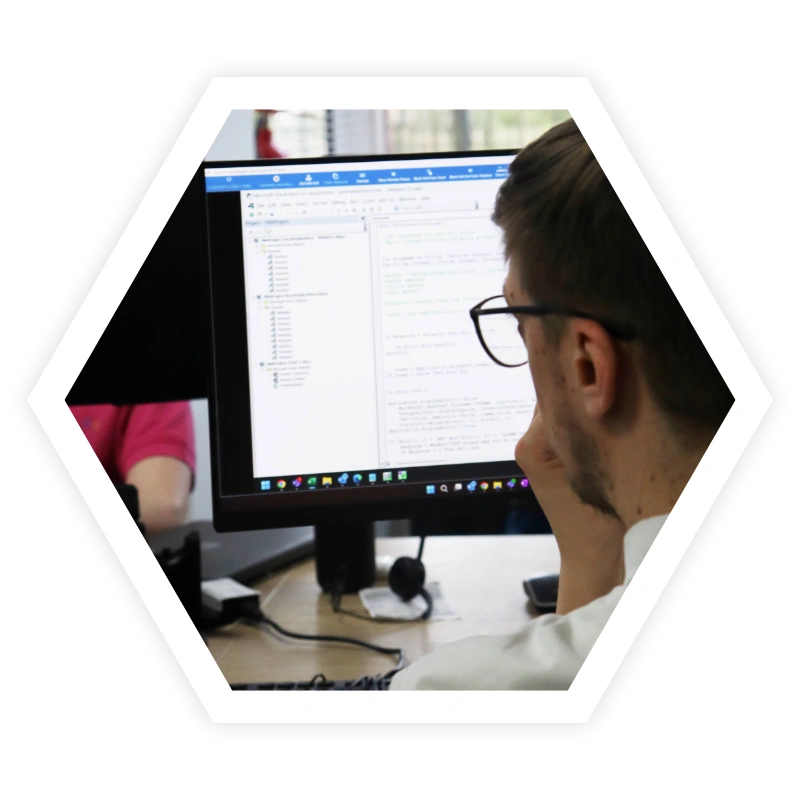 Software developer working on code displayed on a computer screen